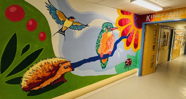 A brightly painted mural of flowers and wildlife on a children's ward.