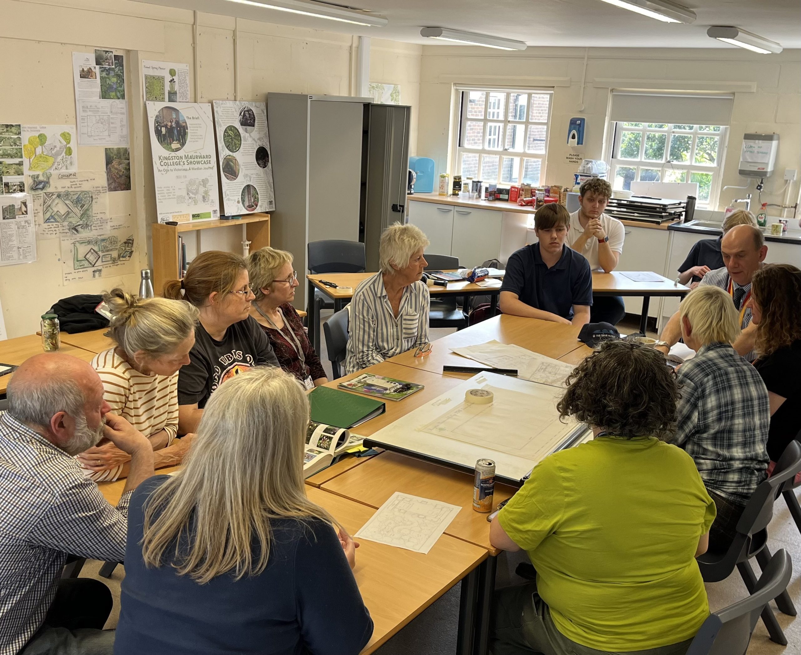 Students from Kingston Maurward College with staff from Dorset County Hospital discussing plans for the sensory garden. Everyone is sat around the table.