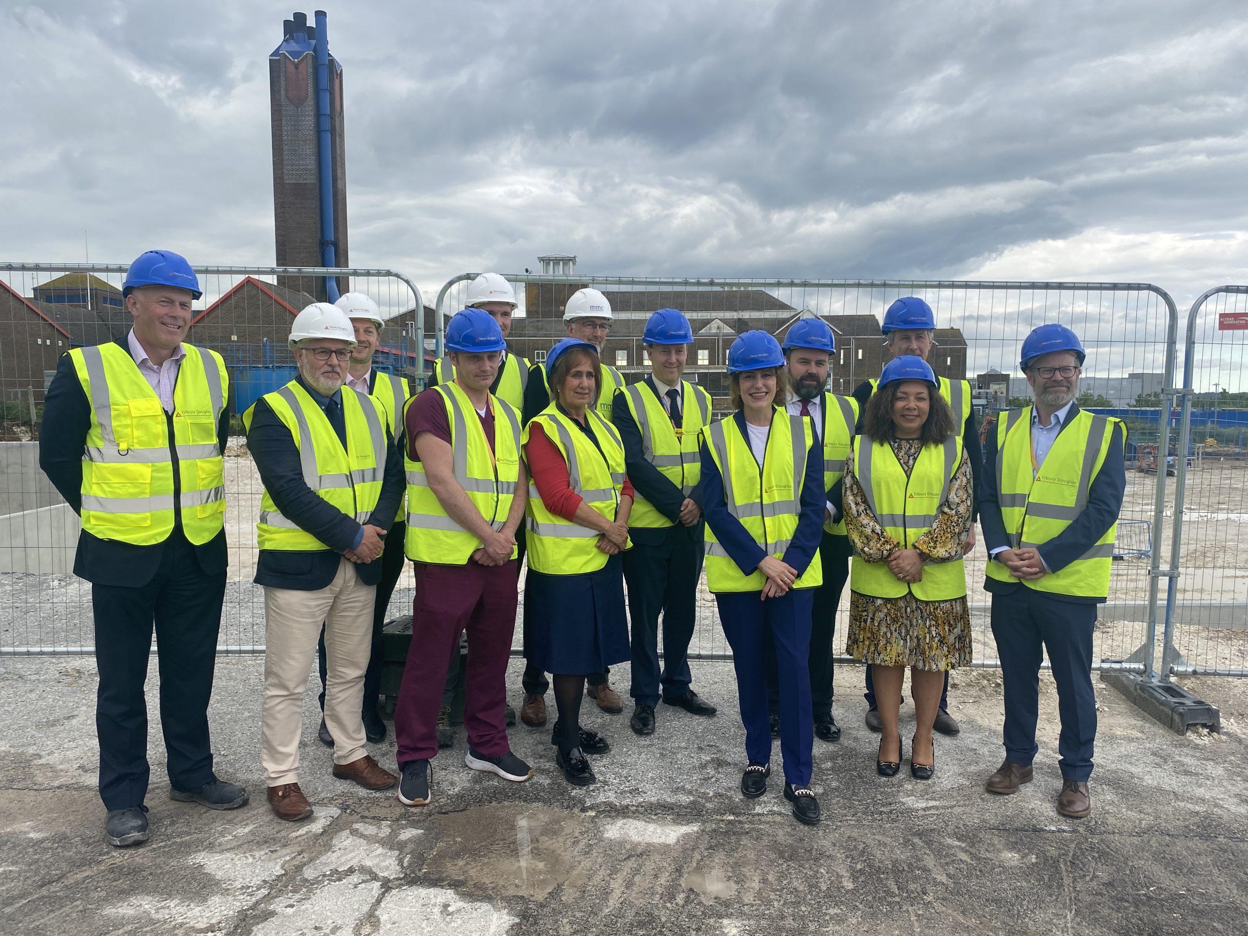 Staff with Victoria Atkin, SoS in hard hats and high vis jackets on a building site