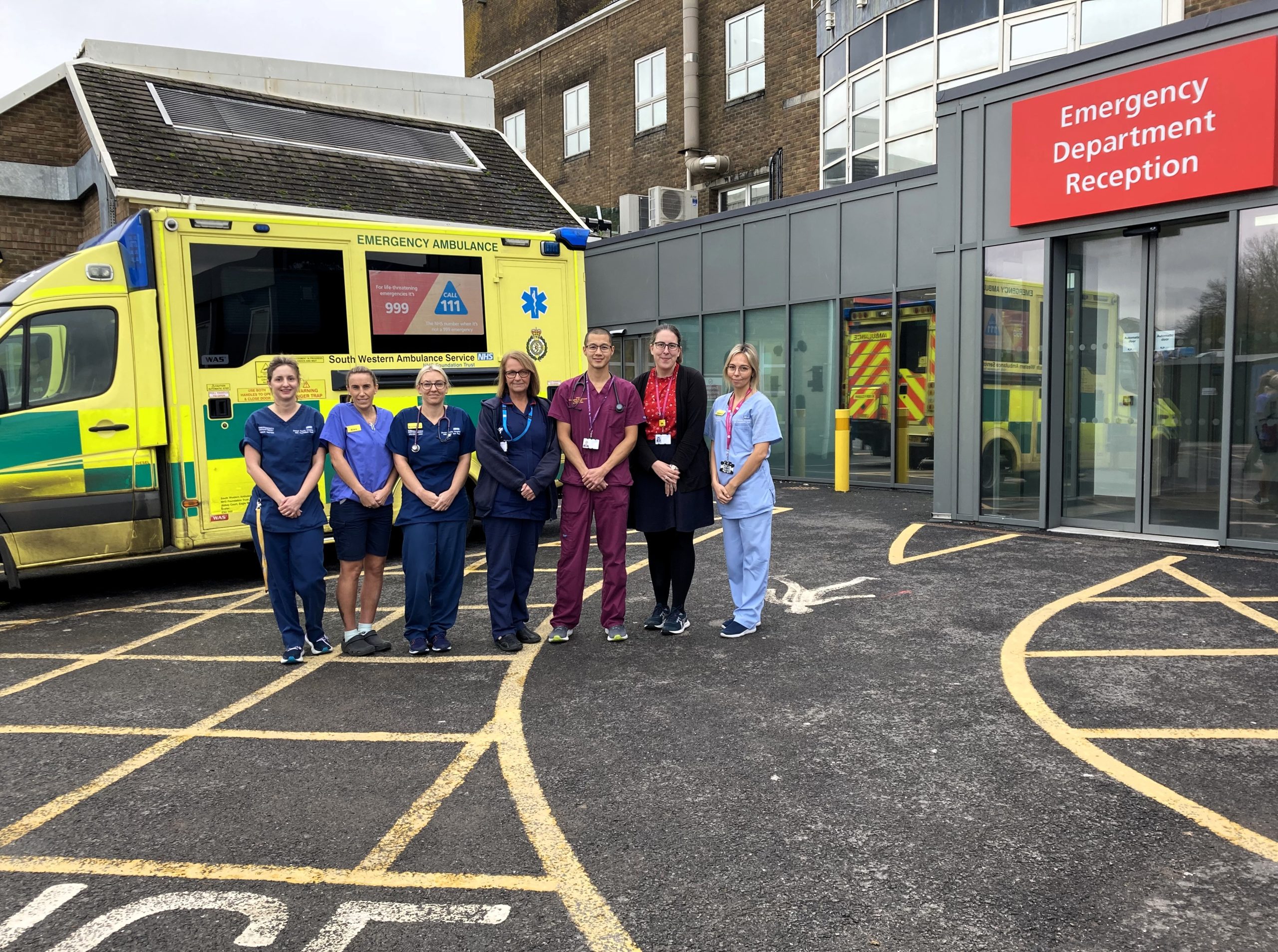 Staff standing in front of an ambulance outside an Emergency Department.