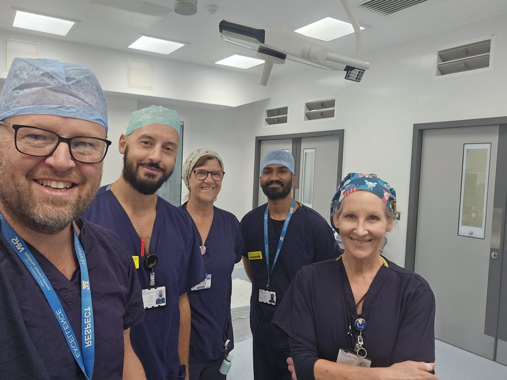 Staff in blue scrubs in theatre space