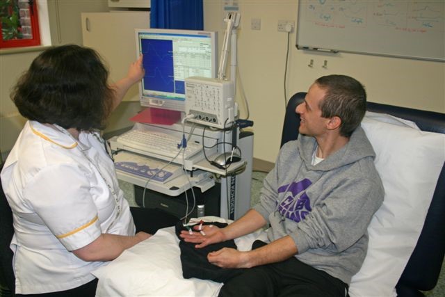 A healthcare worker showing a patient the results of their test on a computer screen.