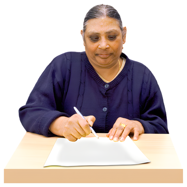 A person sitting at a table writing on a sheet of paper.