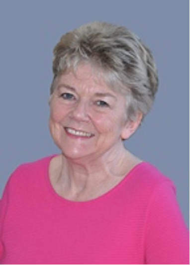 A woman in a pink top smiling at the camera.