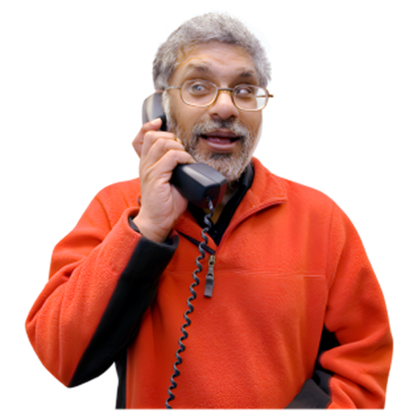 A person in an orange fleece and glasses. They are on the telephone.
