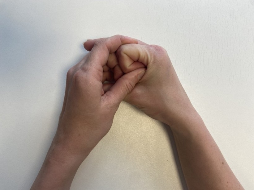 A person's hands clasped together.