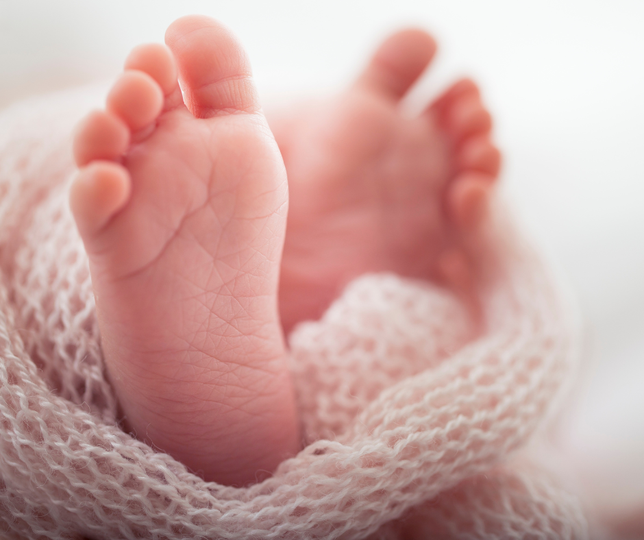 Baby's feet, wrapped in a knitted blanket.